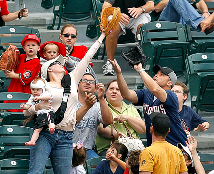 Mom holding baby catches baseball